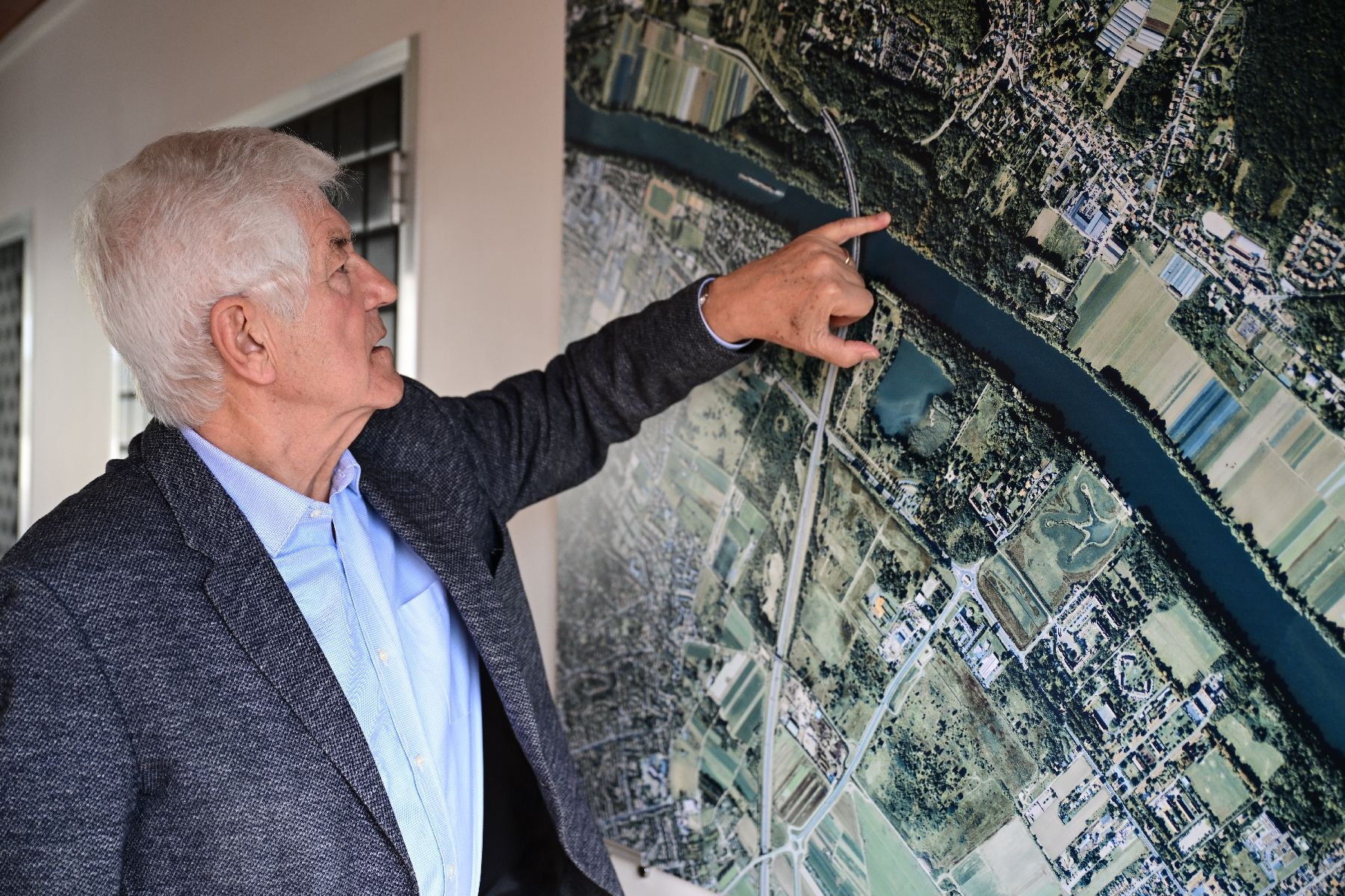 le maire du Mesnil-Le-Roi (DVD), Serge Caseris montre l'emplacement de la "Villa Sapène" sur la carte d'une vue aérienne de la commune, le 24 avril 2024 dans les Yvelines